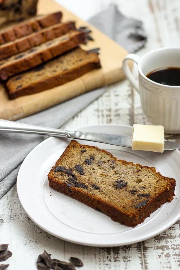 close up of banana bread being served with butter and coffee