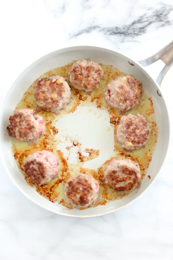 Shot of the meatballs being browned in the pan