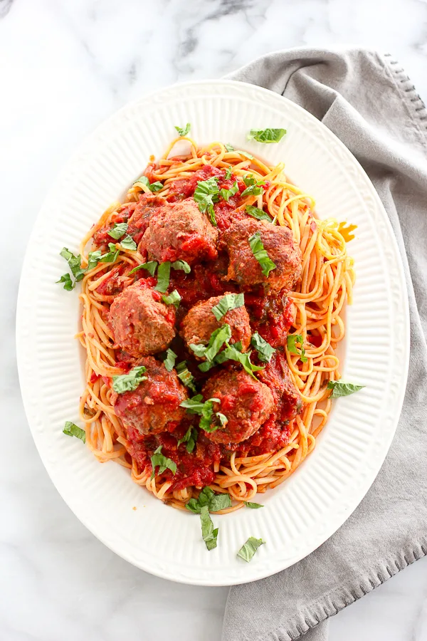 spaghetti and meatballs plated on a serving dish