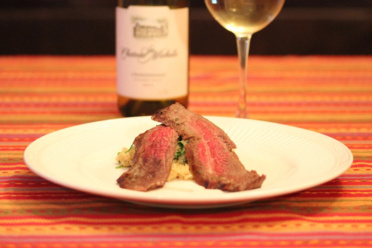 Steak plated with rice and served with a glass of wine