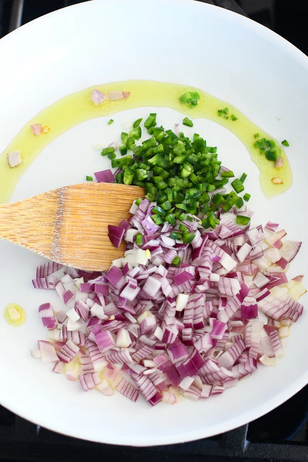 Sautéing the onion an jalapeno pepper in olive oil in a skilled