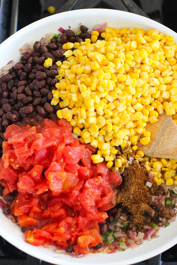 black beans, corn, tomatoes and barbecue sauce ready to be mixed together in the skillet