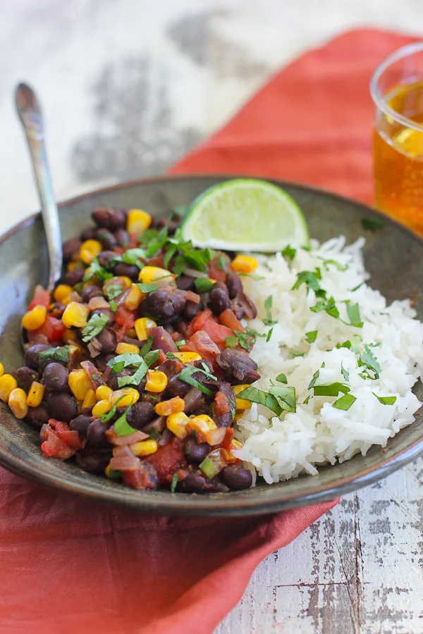 Barbecued Black Beans and Rice plated and garnished with a lime wedge