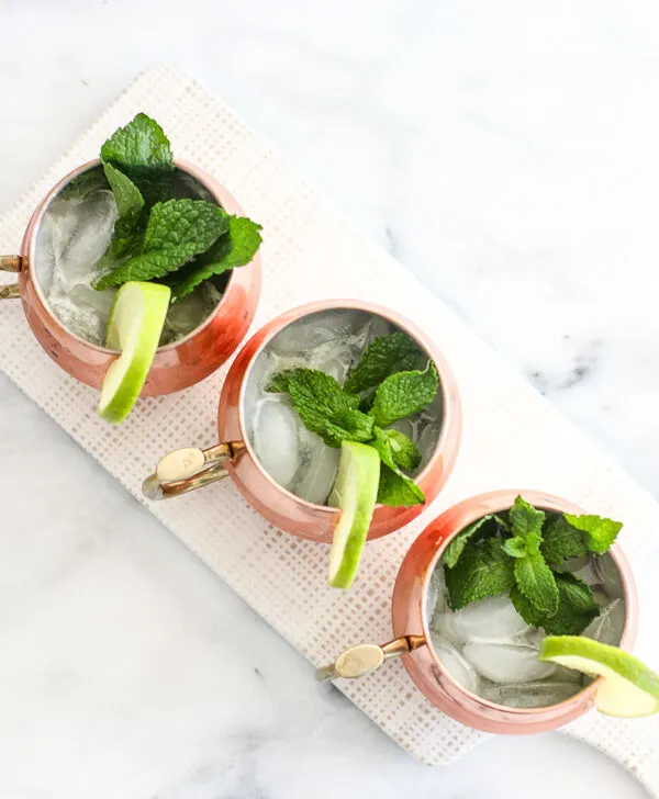 Over head shot of the ginger mint bourbon mules served in a copper mug and garnished with lime and fresh mint