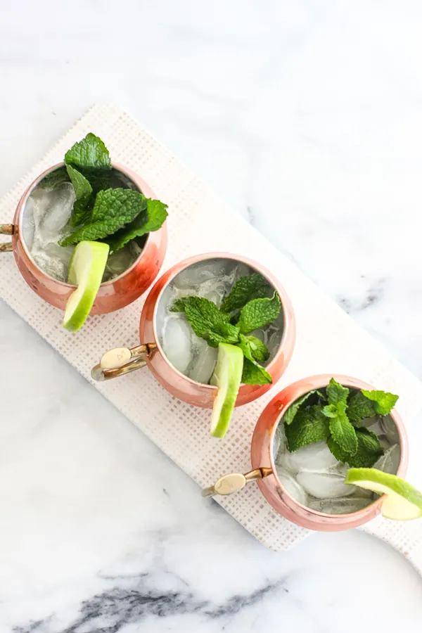 Over head shot of the ginger mint bourbon mules served in a copper mug and garnished with lime and fresh mint