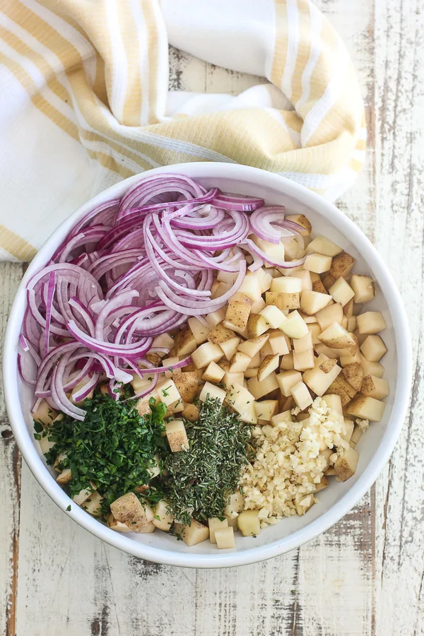 The potatoes in a mixing bowl with the rest of the ingredients before combining.