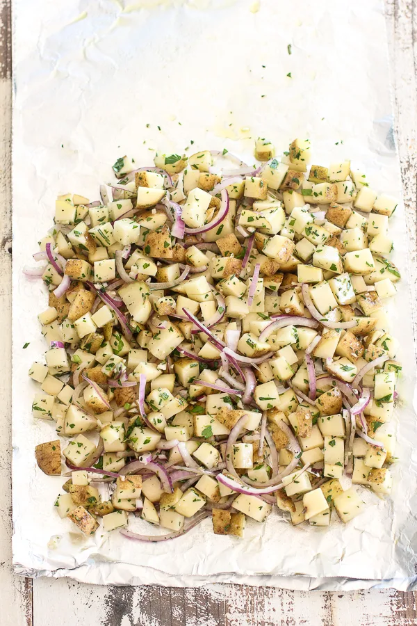 The prepped potatoes on a sheet of foil before wrapping and grilling.