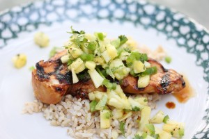 grilled chicken topped with pineapple salsa on a plate