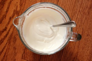 top shot of a bowl of creme fraiche dressing in a bowl with a spoon
