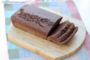 partially sliced loaf of chocolate zucchini bread on a bread board