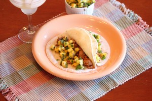 plate with two pulled pork tacos with fresh mango salsa