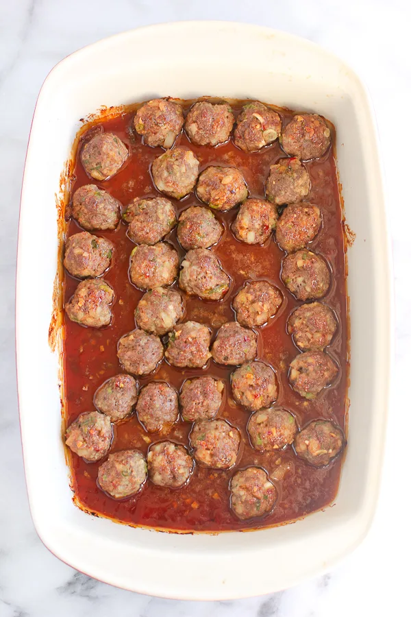 Meatballs in baking dish after sauce has been added