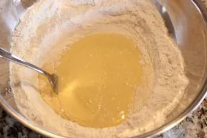 Showing how to incorporate the eggs and the flour together