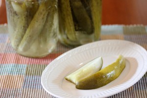 plate with two dill pickles spears with canned pickles in the background