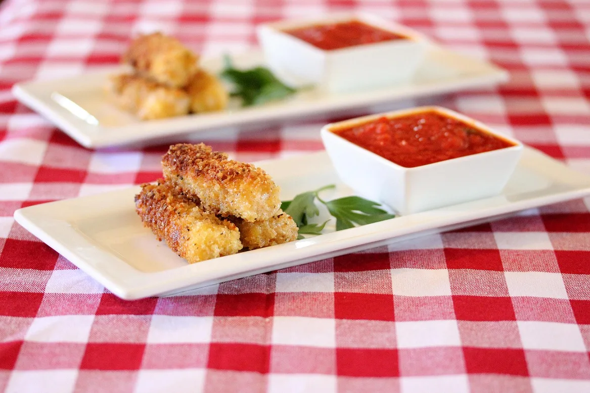 Mozzarella cheese sticks served on rectangular plates with marinara sauce