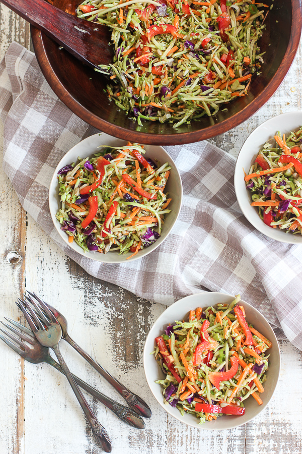 Asian Broccoli Slaw in a wooden serving bowl shown serve in small bowls