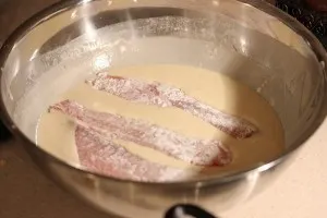 Fish filets being dipped in beer batter