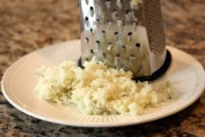 grater with pile of cheese on plate