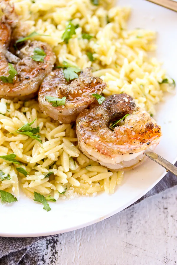 You can have dinner on the table in under 30 minutes with this flavorful, company worthy grilled shrimp with garlicky parmesan orzo.
