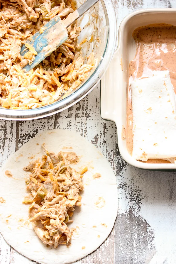 Demonstrating how to assemble the chicken enchiladas