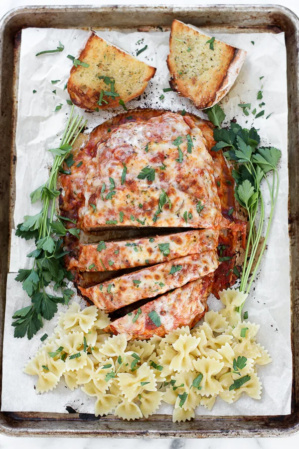 Overhead shot of Italian turkey meatloaf sliced and with pasta and bread