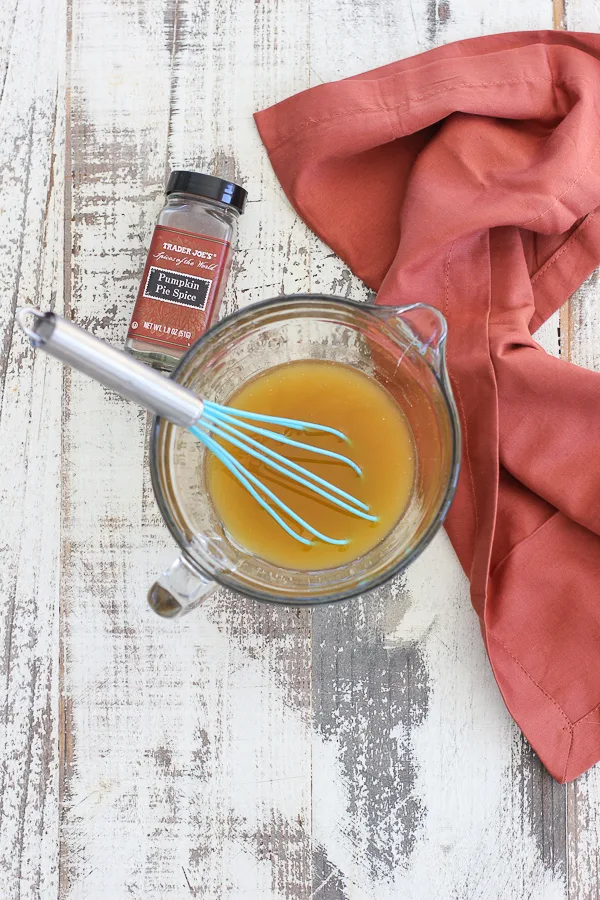 Melted butter in a bowl after whisking in the pumpkin spice.