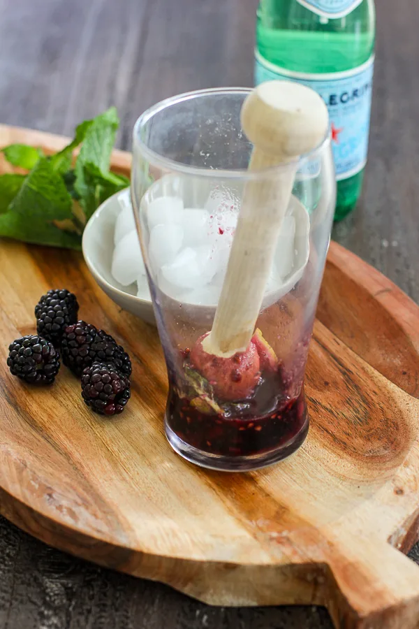 Blackberries, mint and lime after muddling in the cocktail glass