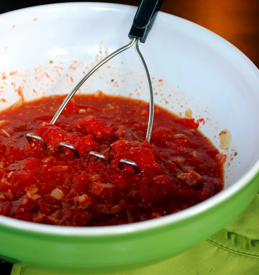 tomato mixture in a bowl after being mashed into a sauce