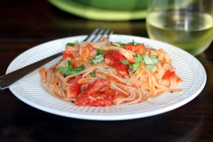 Roasted tomatoes, shallots and pancetta tossed with pasta and plated along with a glass of wine