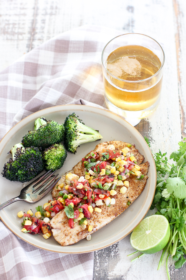 Overhead photo of Pan Seared Tilapia with Grilled Corn Salsa plated with grilled broccoli and served with beer.