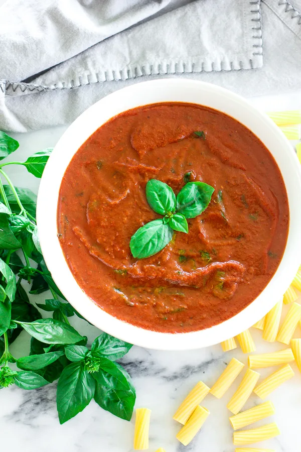 Finished sauce in a serving bowl with basil for garnish.