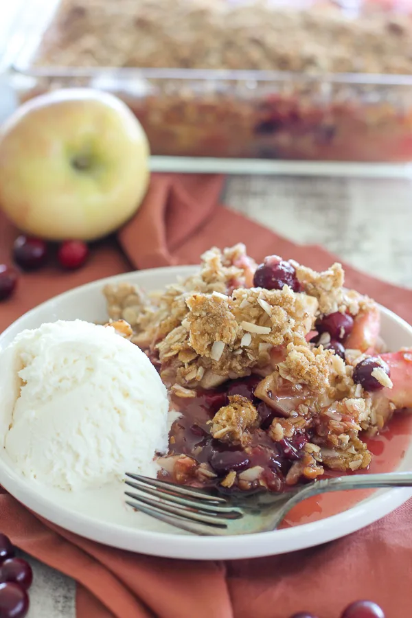 Apple Cranberry Crisp plated with a scoop of vanilla ice cream