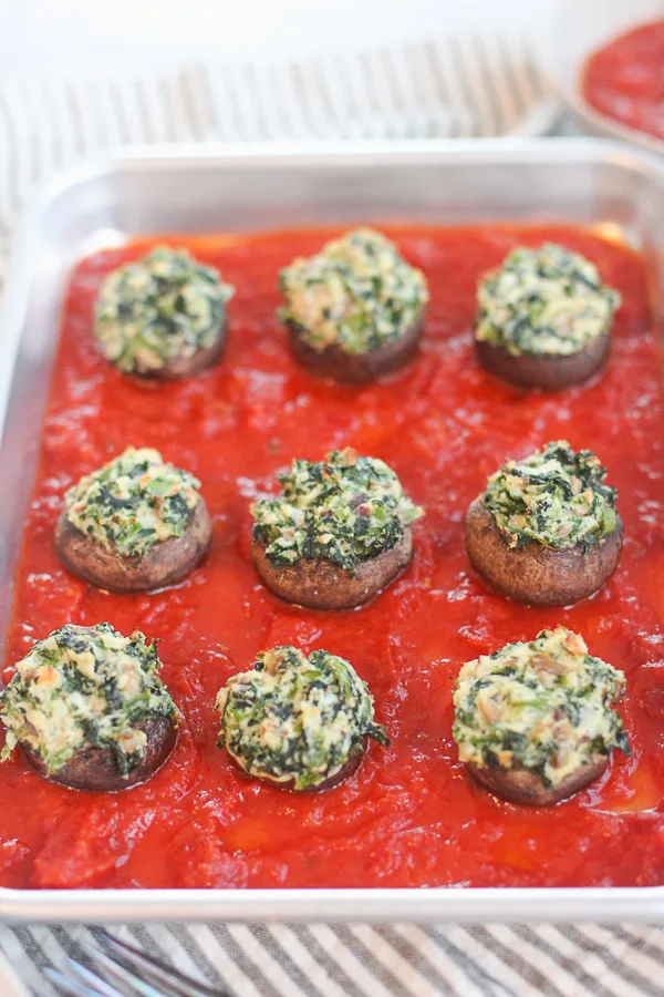 Close up of cooked stuffed plated on a serving tray over marinara sauce