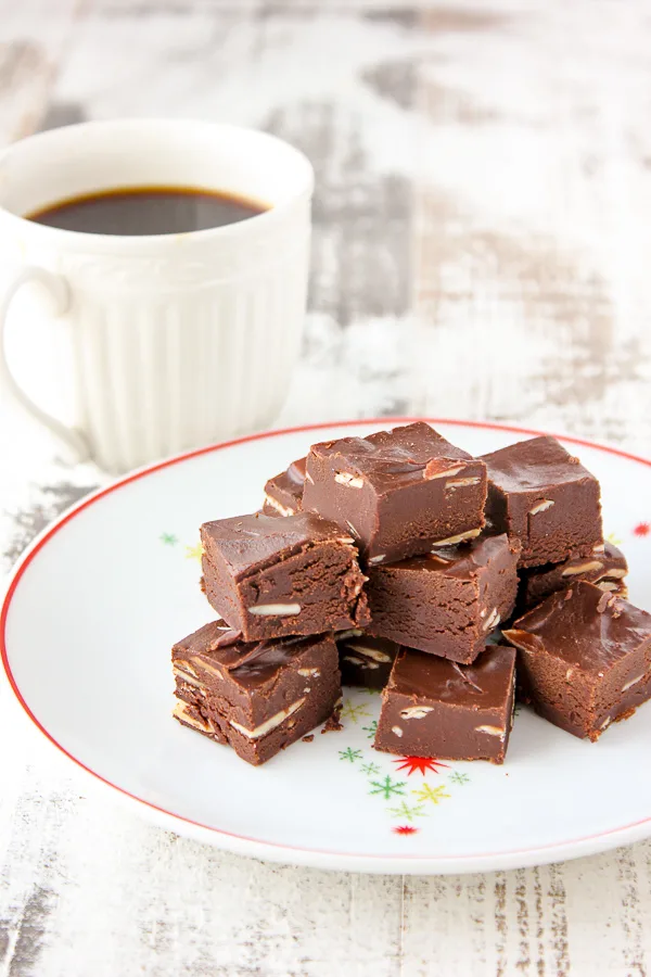 A plate of fudge pieces served with a cup of coffee