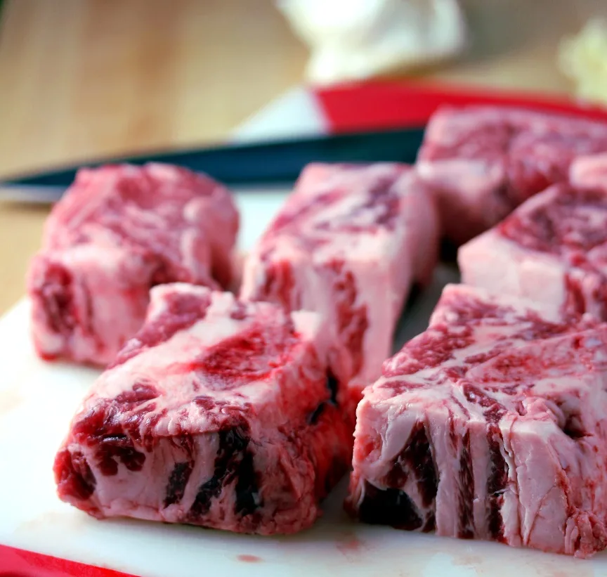Short ribs on a cutting board before searing them