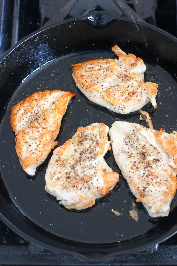 Searing the the chicken breasts in a cast iron skillet after flipping