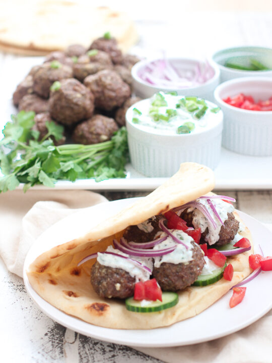 Lamb meatballs served with tzatziki sauce on pita bread with cucumber, red onion and tomato