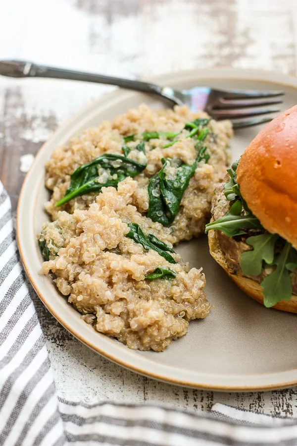 Spinach Parmesan Quinoa plated with a burger