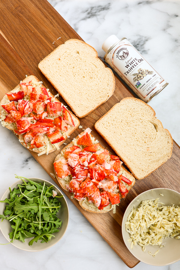 Showing the lobster layered on the bread as the sandwich is being built
