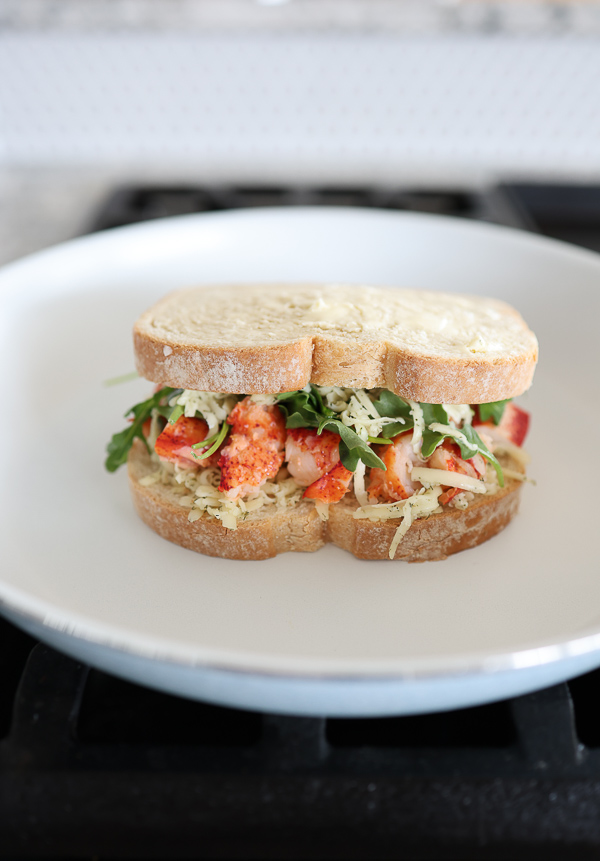 Lobster grilled cheese being grilled in a skillet.