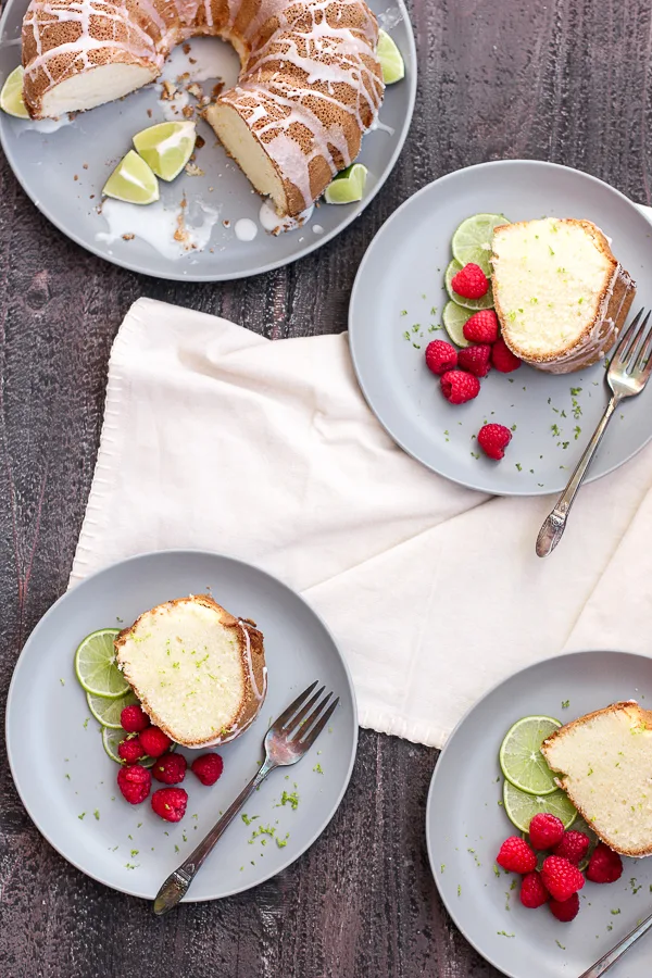 Lime pound cake sliced and served with raspberries and a lime garnish