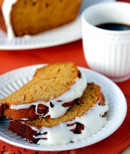 Two slices of pumpkin bread on a plate served with coffee