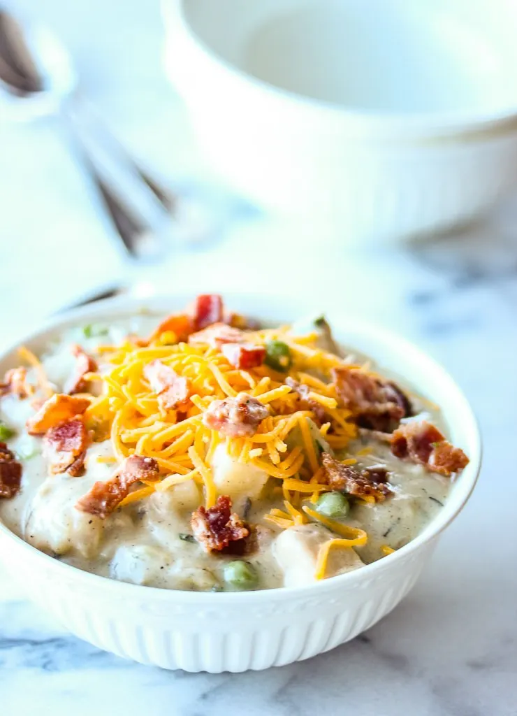 chicken and potato chowder served in a bowl topped with bacon and cheese
