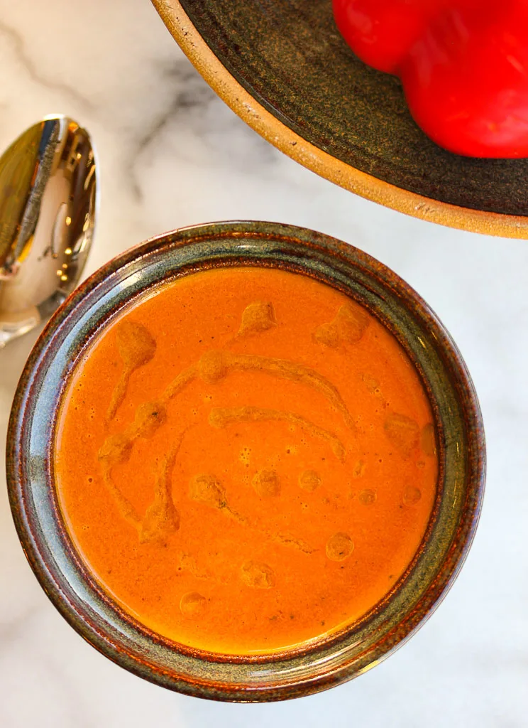 Overhead shot of finished smoky roasted red pepper soup in a bowl