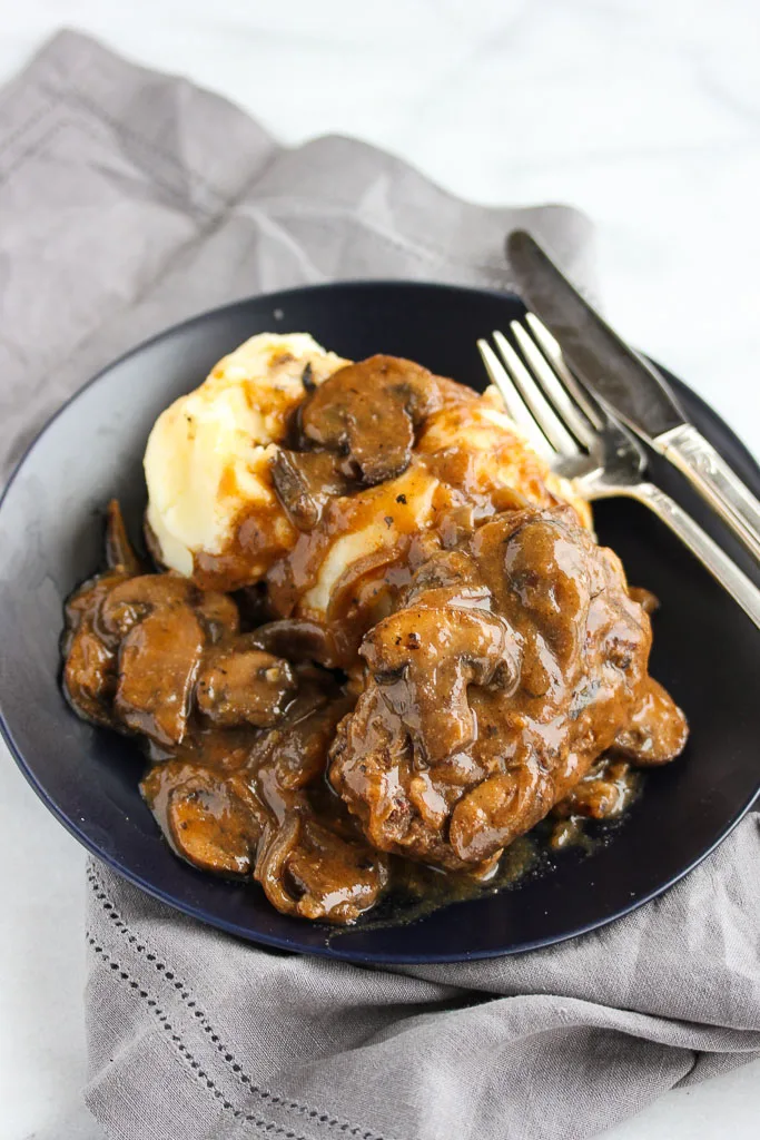 Over head shot of finished salisbury steak with mushrooms over mashed potatoes
