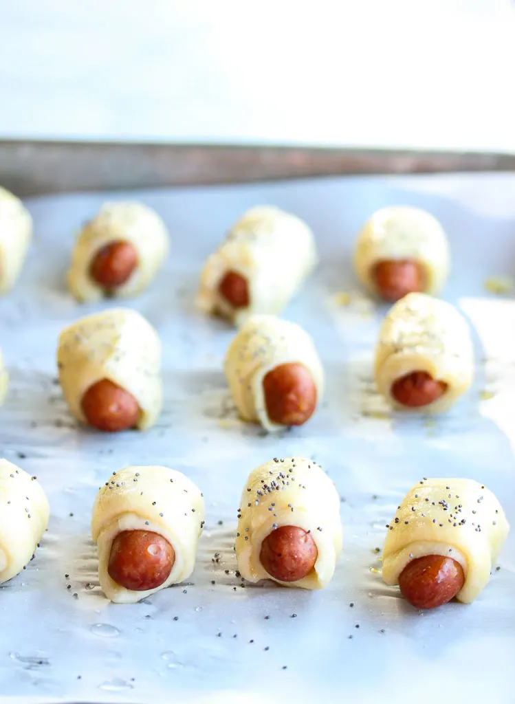 Unbaked pretzel dogs on baking sheet