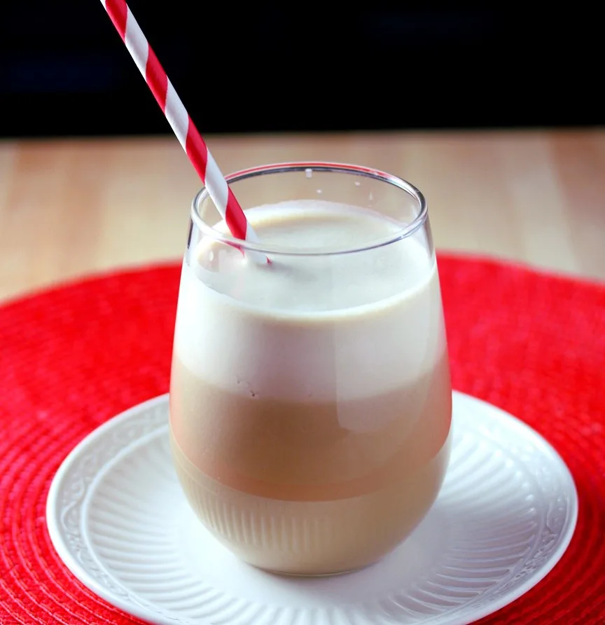 Healthy vanilla protein frappe smoothing served in a glass with a straw
