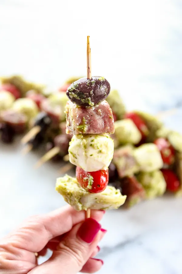 Holding an easy antipasto skewer to show what it looks like when it's assembled.