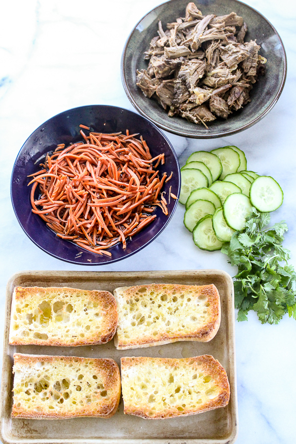 Tender steak and a tangy sauce along with easy pickled carrots make these banh mi inspired slow cooker steak sandwiches something special. | lisasdinnertimedish.com