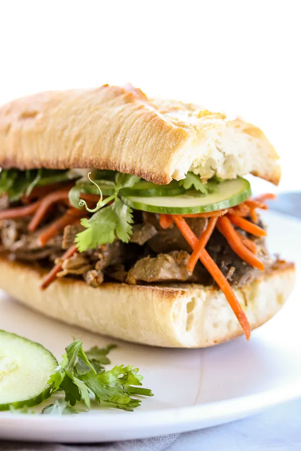 Tender steak and a tangy sauce along with easy pickled carrots make these banh mi inspired slow cooker steak sandwiches something special. | lisasdinnertimedish.com